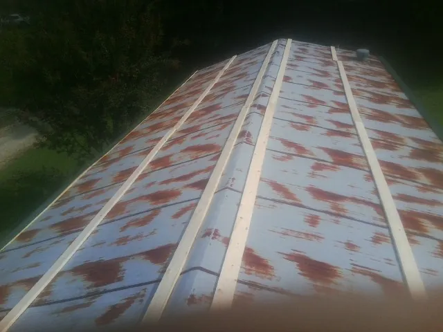 Rusted metal roof panels with new wood purlins before replacement — Storm Damage Roof Repair in Gleneden Beach by Roofing Brothers